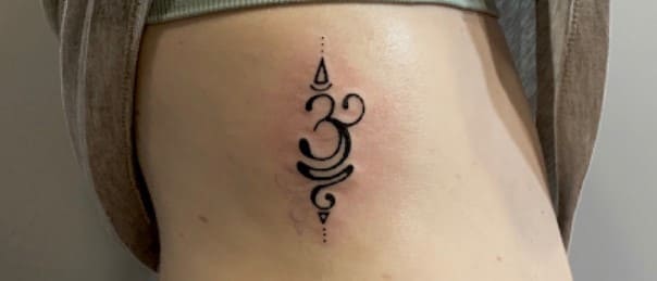 tatuaje símbolo de om en mujer